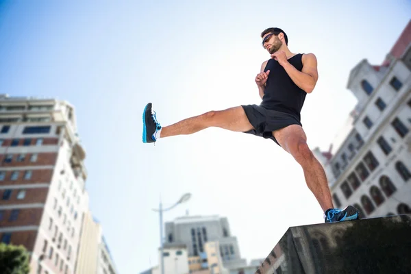 Atleta bonito chutando no ar — Fotografia de Stock