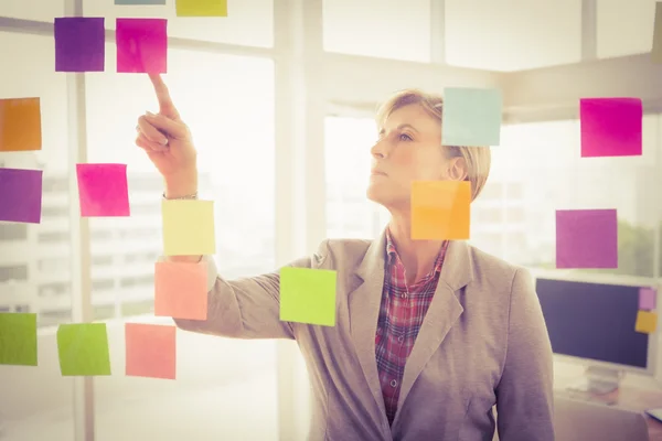 Businesswoman reading sticky notes — Stock Photo, Image