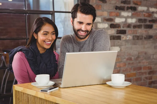 Feliz pareja mirando un ordenador portátil — Foto de Stock