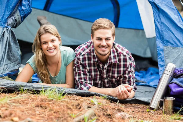 Молодая счастливая пара, лежащая в палатке — стоковое фото