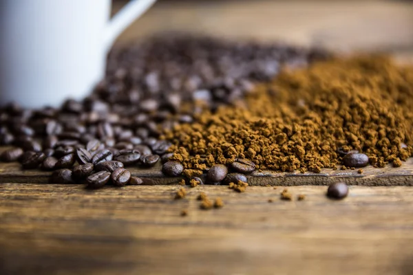 Coffee beans on a table with cup — Stock Photo, Image