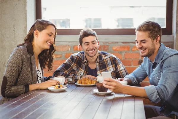 Amigos sorridentes olhando para o smartphone — Fotografia de Stock