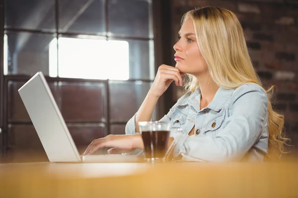 Koncentrerad blondin med laptop — Stockfoto