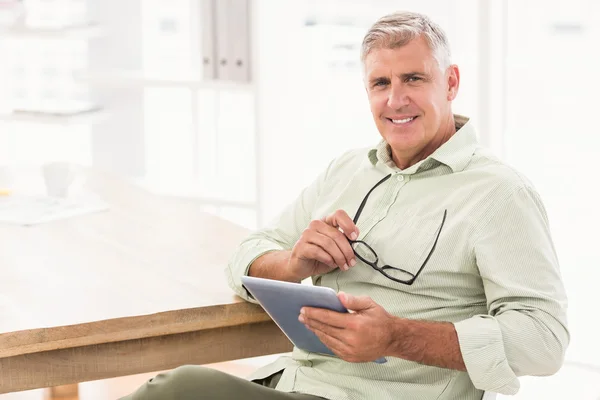 Smiling businessman holding a tablet — Stock Photo, Image