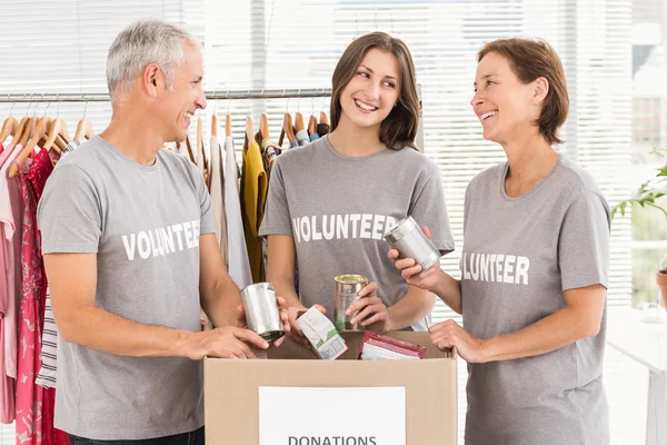 Улыбающиеся волонтеры сортируют пожертвования — стоковое фото