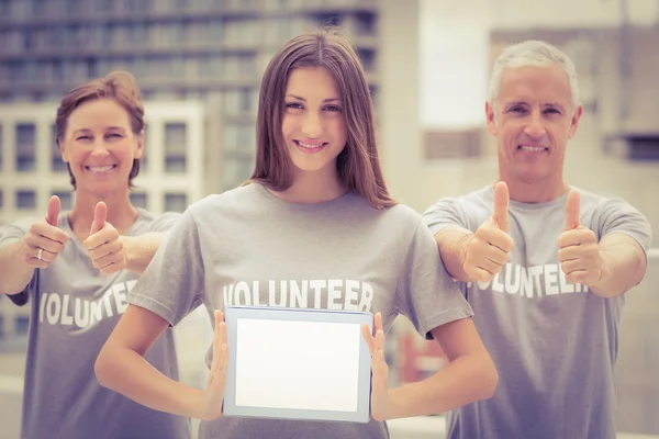 Smiling volunteers showing blank tablet — Stock Photo, Image