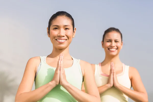 Sonrientes mujeres deportivas haciendo yoga — Foto de Stock