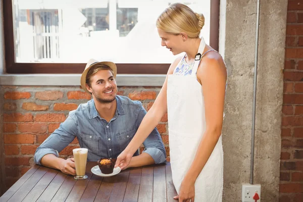 Uśmiechnięta blondynka kelnerka obsługujących muffin — Zdjęcie stockowe