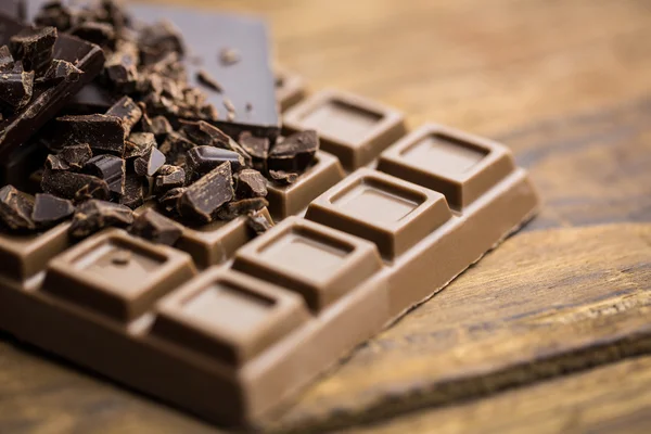 Pedazos de chocolate en una mesa de madera —  Fotos de Stock