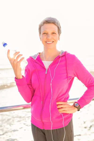 Vrouw met hoofdtelefoon houden fles — Stockfoto