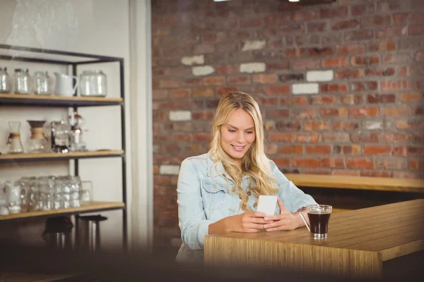 Loira sorridente usando smartphone — Fotografia de Stock