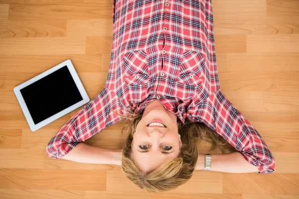 Mulher deitada no chão ao lado do tablet — Fotografia de Stock