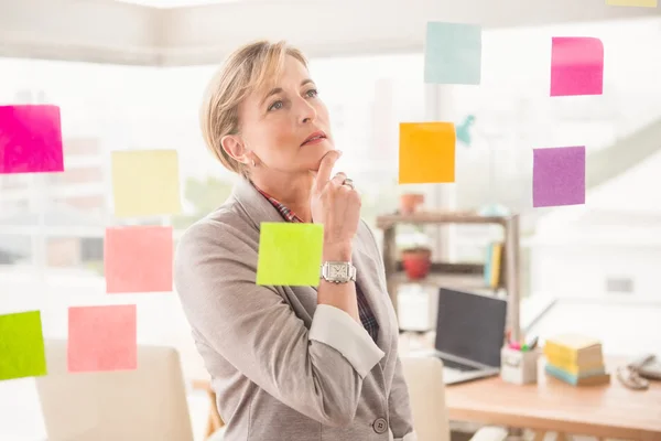 Mujer de negocios leyendo notas adhesivas — Foto de Stock