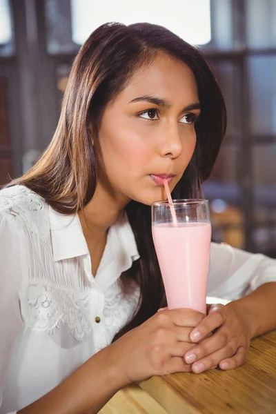 Kvinna som dricker en rosa milkshake — Stockfoto