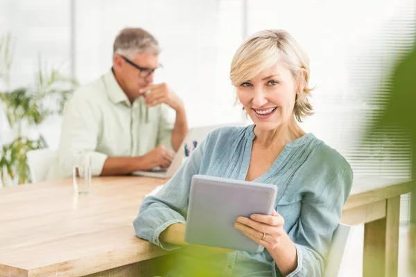 Empresária sorridente trabalhando em um tablet — Fotografia de Stock