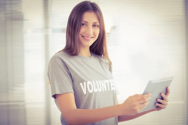 Lachende brunette vrijwilliger met Tablet PC — Stockfoto