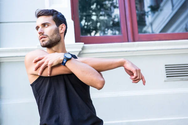 Handsome athlete stretching his arm — Stock Photo, Image