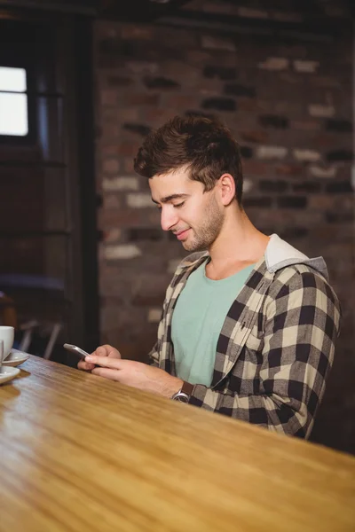 Leende hipster sitter och textning — Stockfoto