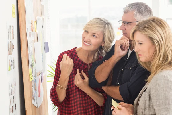 Lachende business team kijken naar notities — Stockfoto