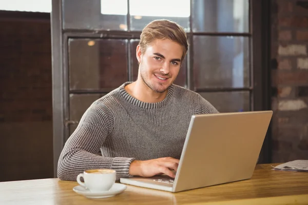 Hombre sonriendo y usando el ordenador portátil — Foto de Stock