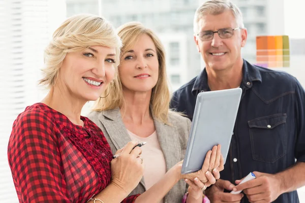 Miling equipe de negócios segurando um tablet — Fotografia de Stock