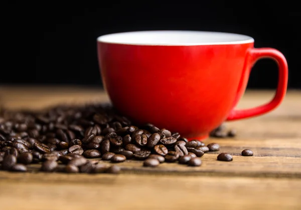 Kaffeebohnen auf einem Tisch mit Tasse — Stockfoto