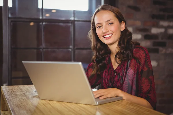Usměvavá brunetka pomocí přenosného počítače — Stock fotografie