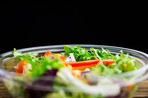 Skål med frisk sallad på bordet — Stockfoto