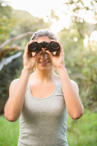 Brunette looking through binoculars — Stock Photo, Image