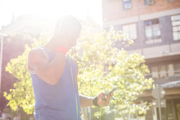 Atleet met behulp van zijn telefoon — Stockfoto