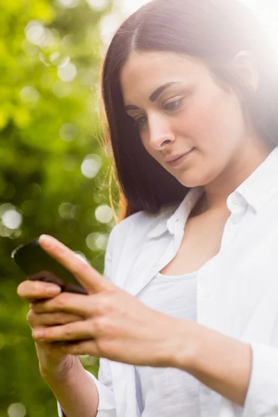 Brunett skicka ett textmeddelande — Stockfoto