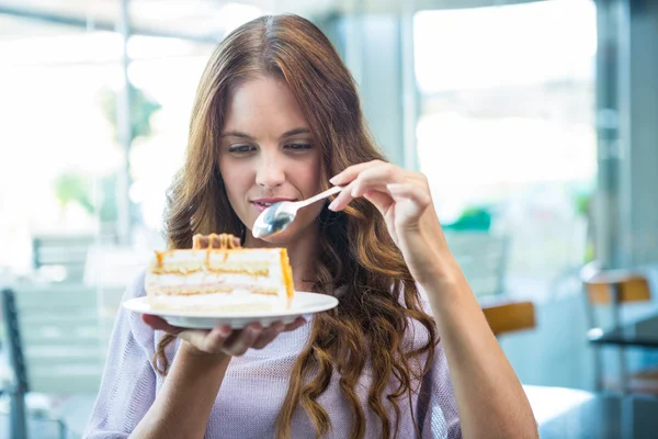 Bonita morena disfrutando de un pastel — Foto de Stock