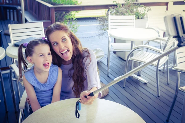 Mãe e filha usando selfie stick — Fotografia de Stock