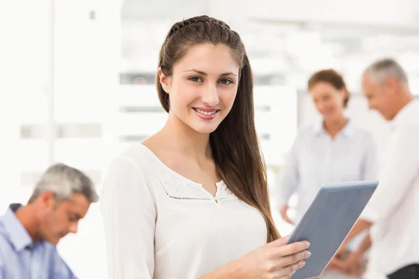 Glimlachende zakenvrouw met tablet in een vergadering — Stockfoto