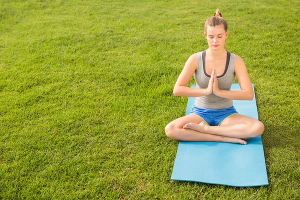 Loira meditando no tapete de exercício — Fotografia de Stock