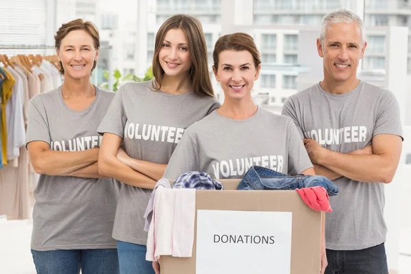Voluntarios sonrientes con caja de donaciones — Foto de Stock