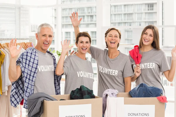 Lachende vrijwilligers zwaaien — Stockfoto