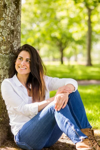 Vacker brunett avkopplande i parken — Stockfoto