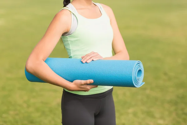 Mulher segurando tapete de exercício — Fotografia de Stock