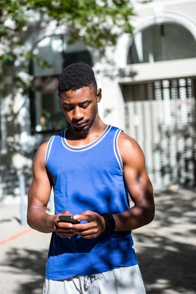 Bello atleta usando il suo telefono — Foto Stock