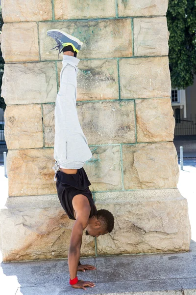 Przystojny sportowiec robi headstand — Zdjęcie stockowe