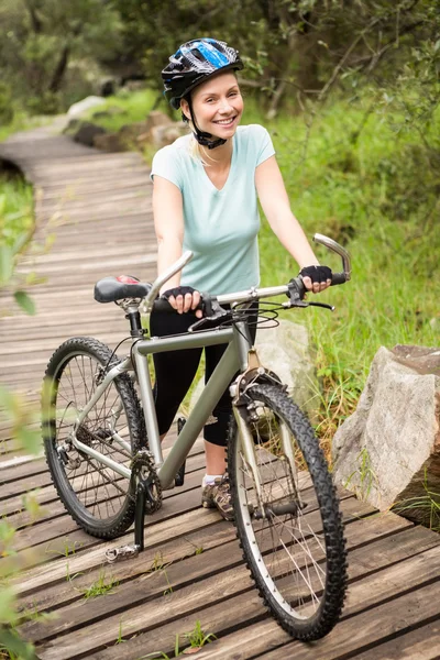 Sorridente donna in forma rotolando la sua moto — Foto Stock