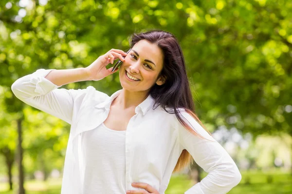 Brünette im Park telefoniert — Stockfoto