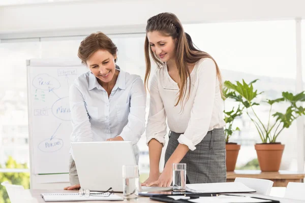 Mulheres de negócios sorridentes usando laptop — Fotografia de Stock