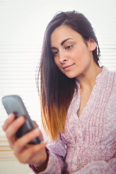 Brunette gebruikend haar smartphone — Stockfoto