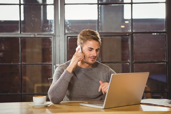 Homem telefonando e olhando para laptop — Fotografia de Stock