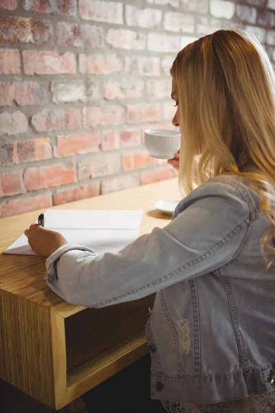 Blonde kop koffie en schrijven — Stockfoto