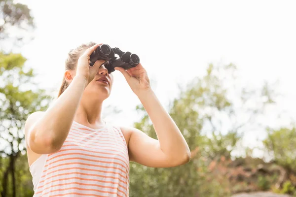 Blondin tittar genom kikare — Stockfoto