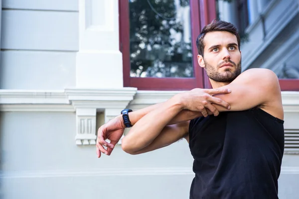 Apuesto atleta estirando su brazo —  Fotos de Stock