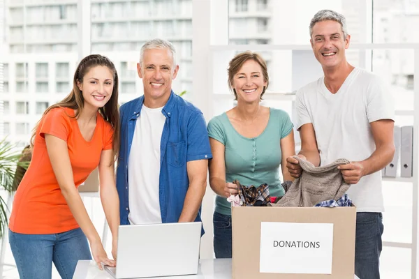 Lachende casual zakenmensen met donatie box — Stockfoto